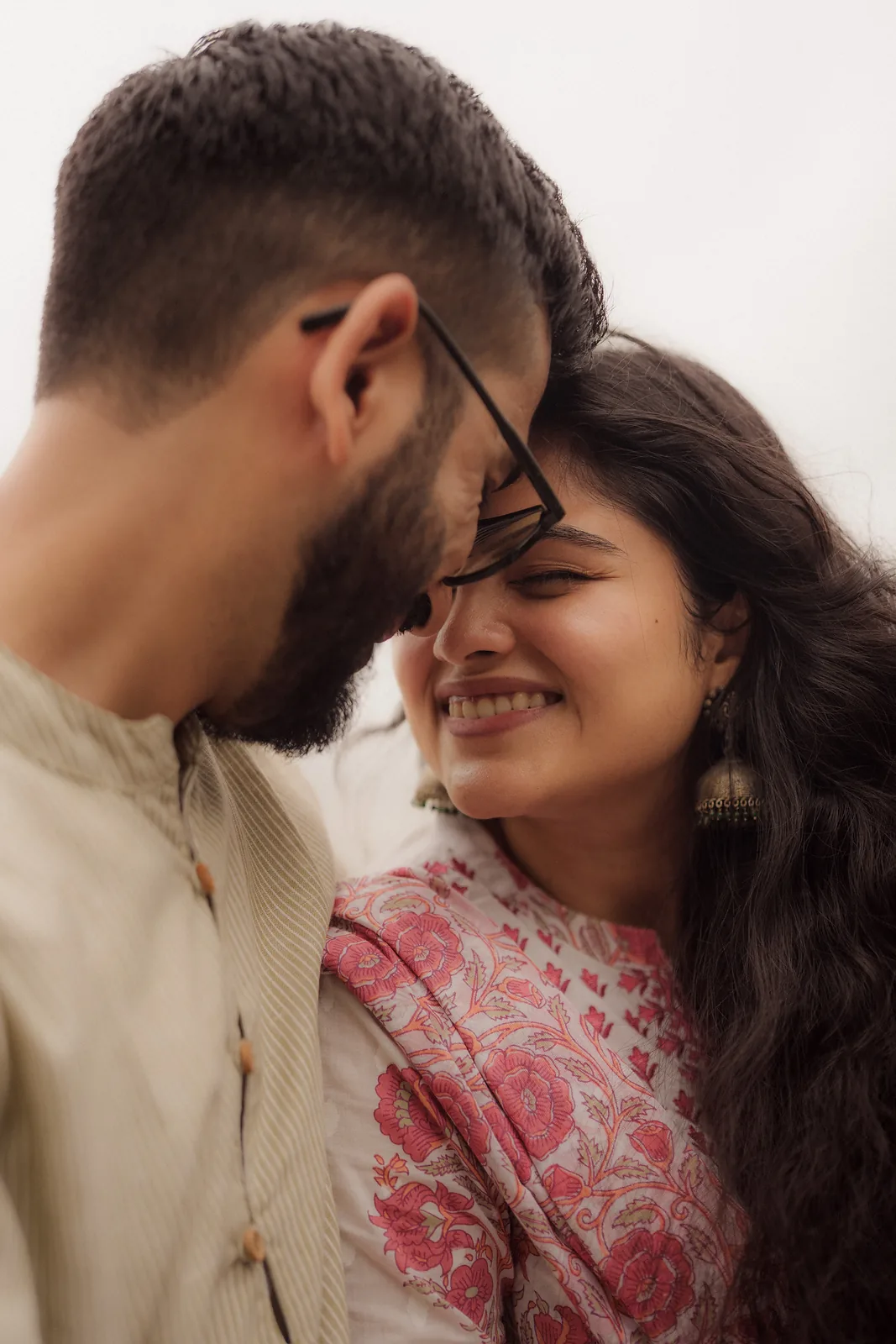 Foreheads touching, eyes closed, smiling